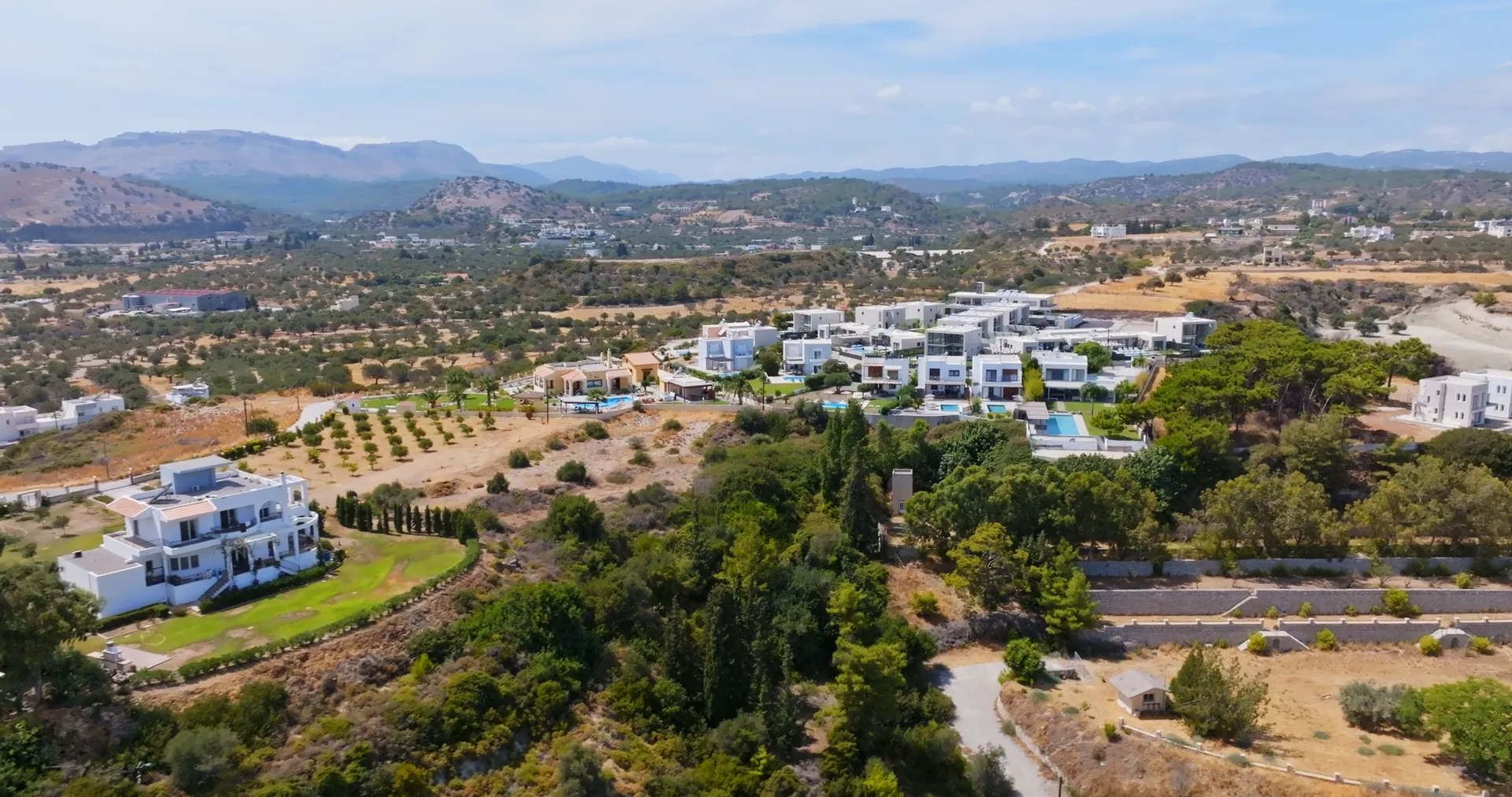 Aerial view of white villas among olive groves and pines in the hills of Benahavís