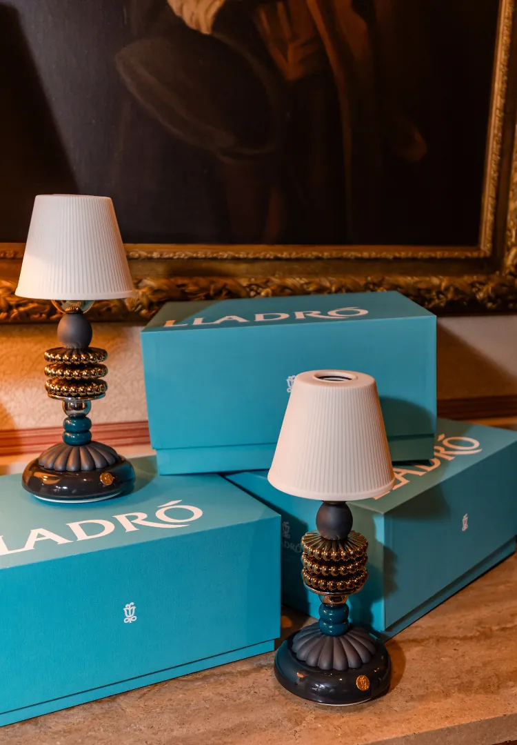 Two Lladró Firefly lamps beside their turquoise Lladró boxes
