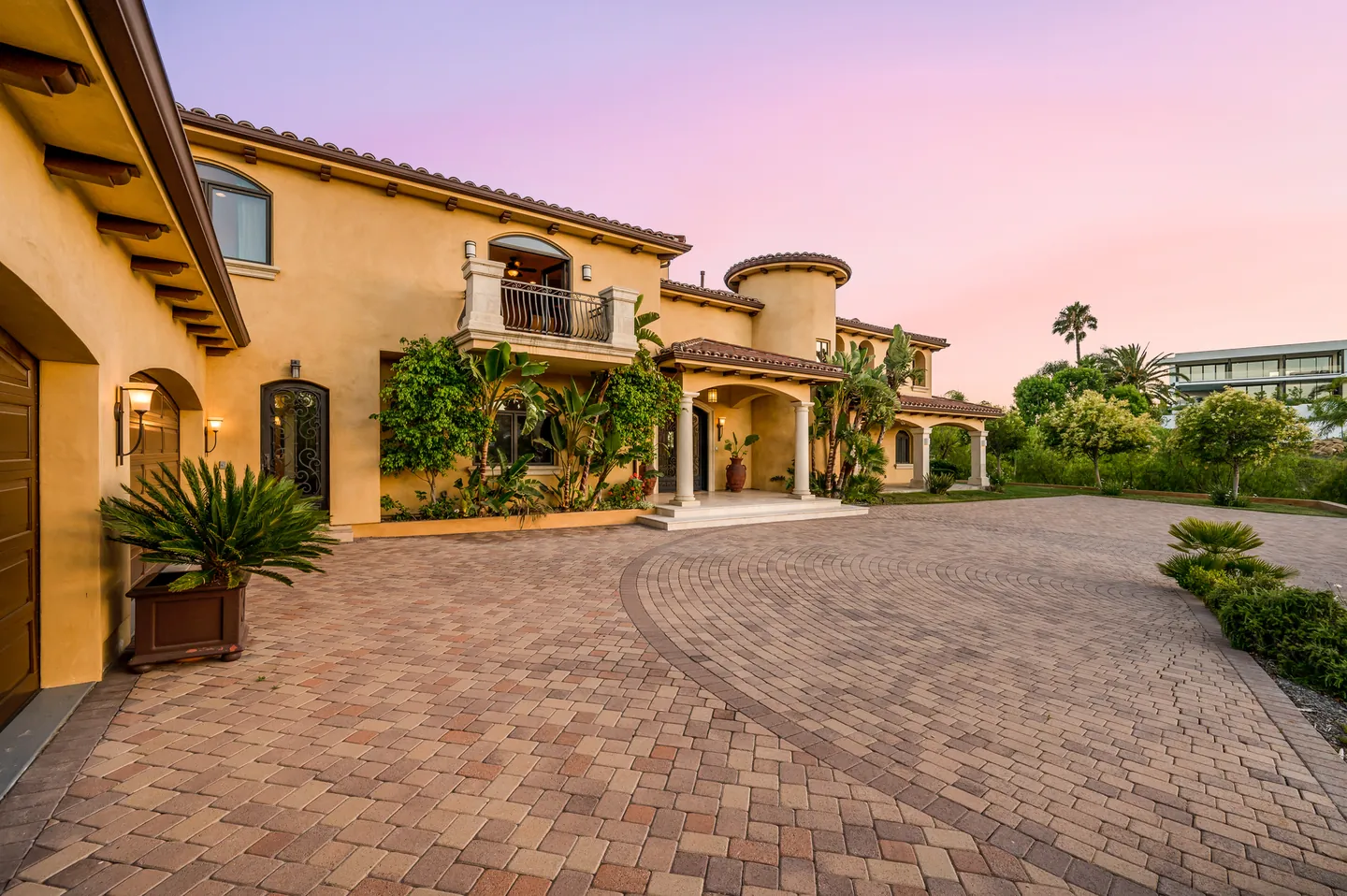Mediterranean villa with a paved forecourt, palms and climbing plants