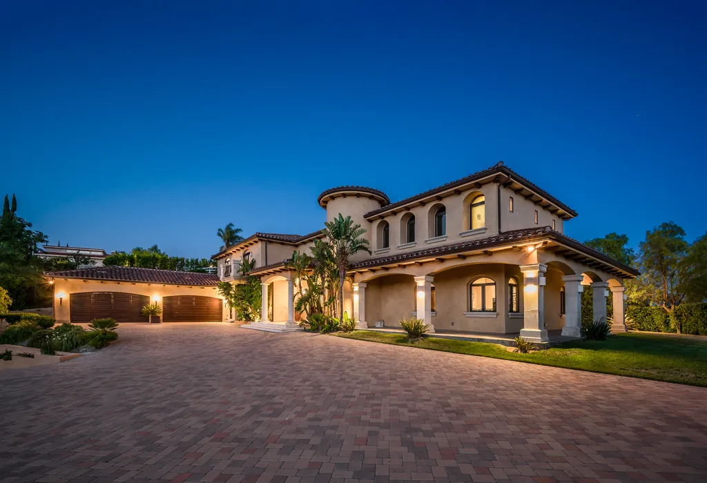 Mediterranean villa with arches and tiled roofs lit at dusk