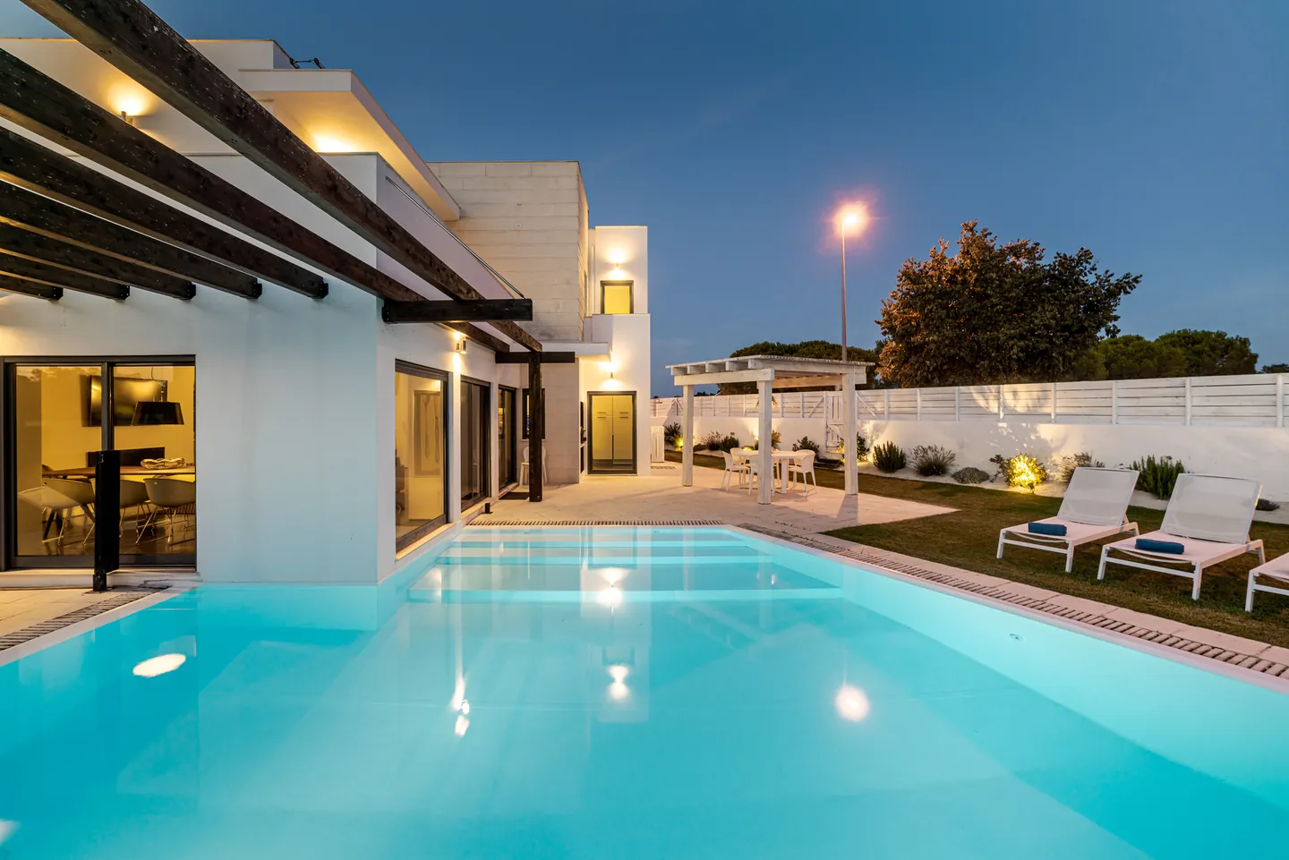 Contemporary villa with a pergola and pool terrace in the evening